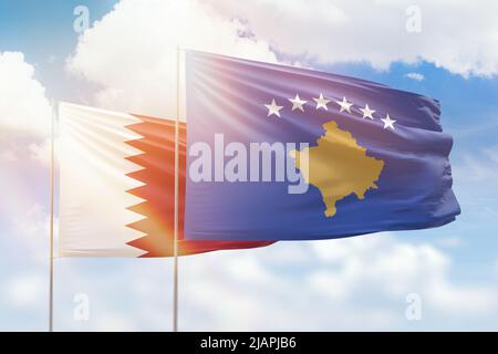 Ciel bleu ensoleillé et drapeaux du kosovo et du qatar Banque D'Images