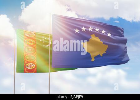 Ciel bleu ensoleillé et drapeaux du kosovo et du turkménistan Banque D'Images