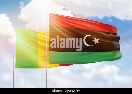 Ciel bleu ensoleillé et drapeaux de la libye et du mali Banque D'Images