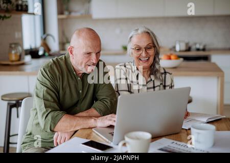 Un couple senior heureux calcule les dépenses ou le budget de planification ensemble à la maison. Banque D'Images