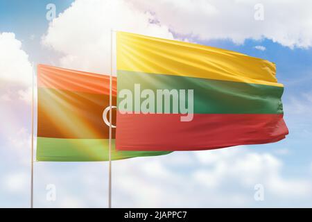 Ciel bleu ensoleillé et drapeaux de la lituanie et de la libye Banque D'Images