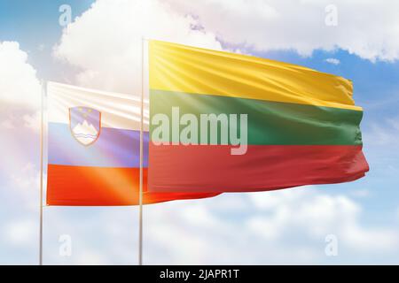 Ciel bleu ensoleillé et drapeaux de la lituanie et de la slovénie Banque D'Images