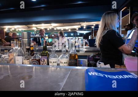 Les gens s'assoient dans un bar au marché de nuit d'été de Tucson. Flou intentionnel de l'appareil photo en cas d'exposition prolongée Banque D'Images