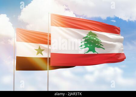 Ciel bleu ensoleillé et drapeaux du liban et de la syrie Banque D'Images