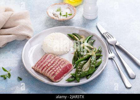 Steak de thon poêlé avec riz blanc et pois verts Banque D'Images