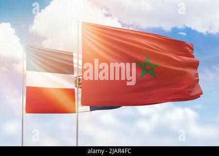 Ciel bleu ensoleillé et drapeaux du maroc et de la république dominicaine Banque D'Images