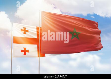 Ciel bleu ensoleillé et drapeaux du maroc et de la géorgie Banque D'Images