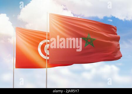 Ciel bleu ensoleillé et drapeaux du maroc et de la tunisie Banque D'Images