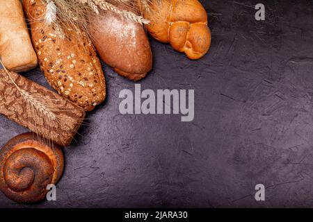 Divers petits pains et pains savoureux avec grain gros plan sur fond gris. Banque D'Images