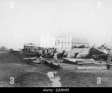 Trois hommes parmi les débris d'un bâtiment qui s'est effondré après le cyclone de 1897 à Darwin, alors connu sous le nom de Palmerston, dans le territoire du Nord de l'Australie ca. 8 février 1897 Banque D'Images