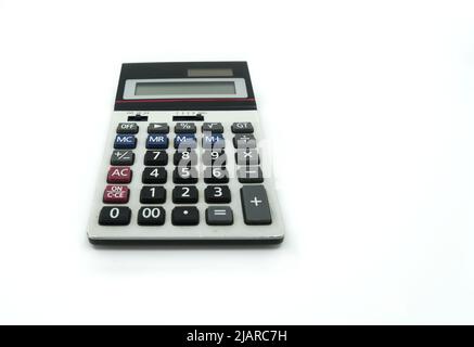 Vue en perspective une petite calculatrice ancienne sur fond blanc, une calculatrice avec un bouton ancien et quelques marques de l'utilisation. Banque D'Images