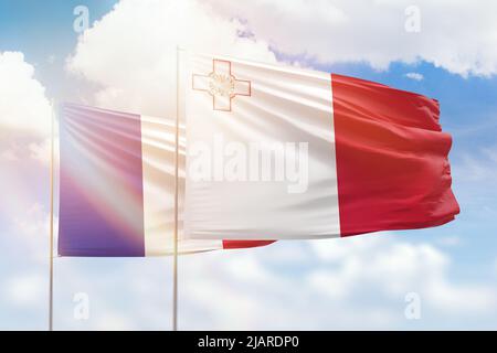 Ciel bleu ensoleillé et drapeaux de malte et de france Banque D'Images