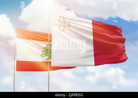 Ciel bleu ensoleillé et drapeaux de malte et du liban Banque D'Images