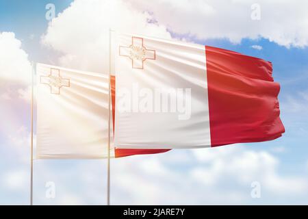 Ciel bleu ensoleillé et drapeaux de malte et de malte Banque D'Images