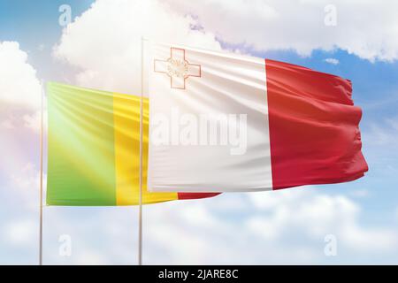 Ciel bleu ensoleillé et drapeaux de malte et du mali Banque D'Images