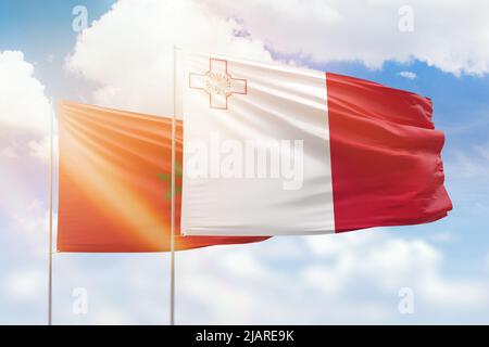 Ciel bleu ensoleillé et drapeaux de malte et du maroc Banque D'Images