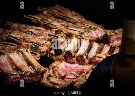 côte de bœuf juteuse et côte de porc lentement sur le gril au feu d'un barbecue à gaz Banque D'Images