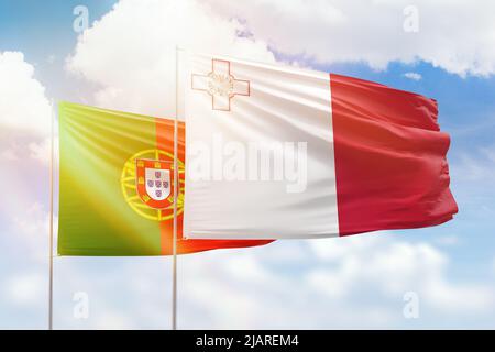 Ciel bleu ensoleillé et drapeaux de malte et du portugal Banque D'Images