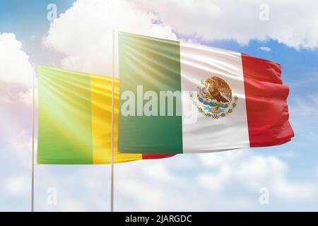 Ciel bleu ensoleillé et drapeaux du mexique et du mali Banque D'Images