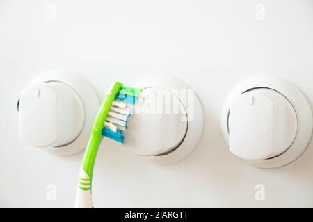 Brosse à dents nettoie le bouton de la cuisinière à gaz de la saleté, le nettoyage et le nettoyage, laver la cuisinière à gaz dans la cuisine à la maison Banque D'Images