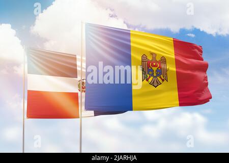 Ciel bleu ensoleillé et drapeaux de la moldavie et de la république dominicaine Banque D'Images