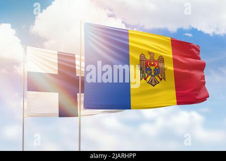 Ciel bleu ensoleillé et drapeaux de la moldavie et de la finlande Banque D'Images