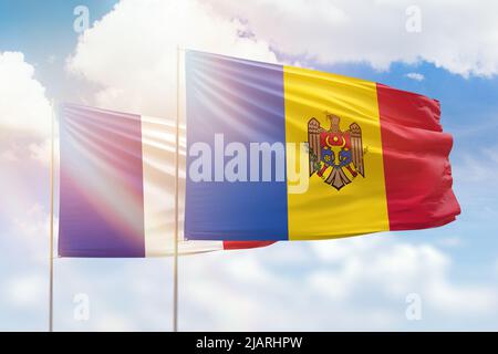 Ciel bleu ensoleillé et drapeaux de la moldavie et de la france Banque D'Images