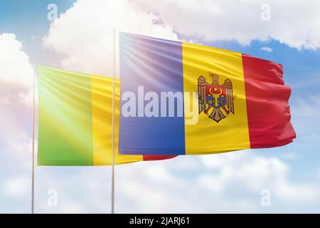 Ciel bleu ensoleillé et drapeaux de la moldavie et du mali Banque D'Images