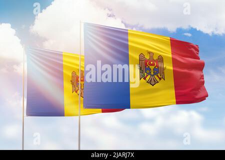 Ciel bleu ensoleillé et drapeaux de la moldavie et de la moldavie Banque D'Images