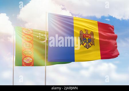 Ciel bleu ensoleillé et drapeaux de la moldavie et du turkménistan Banque D'Images