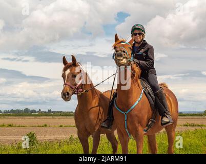 Une femme à cheval. Dressage de la femme à cheval dans le parc. Sportif équestre. Photo de rue, sélection, éditorial-29 mai,2022-Vancouve Banque D'Images