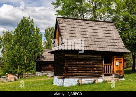 Skansen avec des maisons de village en bois près du château de Sara Lubovna en Slovaquie en été. Banque D'Images