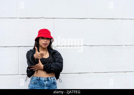 Jeune femme latine hip hop dansant dans la rue avec un chapeau rouge, Panama, Amérique centrale - photo de stock Banque D'Images