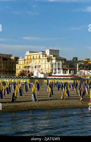 Lignes de parasols et chaises longues jaune vif et bleu foncé sur la plage d'Ostia, Rome, Italie, Europe, Union européenne, UE Banque D'Images