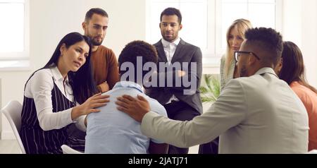 Les personnes en thérapie de groupe, les amis ou les collègues essayant de réconforter et de soutenir la femme triste Banque D'Images