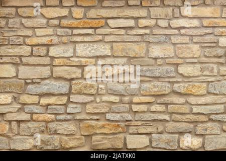 Mur en pierre jaune et beige Uni. Arrière-plan en pierre. Banque D'Images
