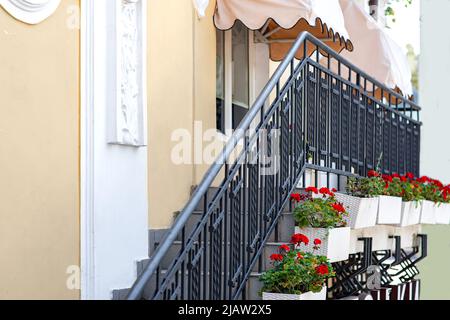 façade du bâtiment avec un escalier extérieur avec balustrade noire et stuc sur le mur et pare-soleil décoratifs au-dessus des fenêtres et flo décoratif Banque D'Images