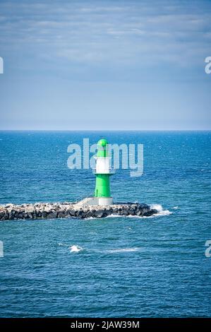 Phare blanc vert sur la rivière Warnow à Rostock sur la mer Baltique. Point de repère de la ville. Vagues sur le bord de la pierre. Photo de paysage de l'Allemagne Banque D'Images