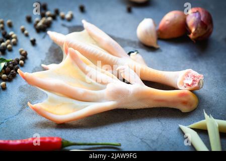 Pieds de canard avec épices d'herbes prêtes à cuire sur l'assiette, pieds de canard frais pour la nourriture Banque D'Images