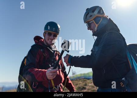 Homme aidant le pilote de parapente à se préparer au vol. Banque D'Images