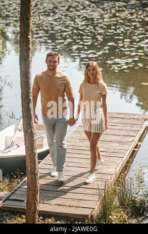 Couple amoureux marchant le long d'une jetée en bois Banque D'Images