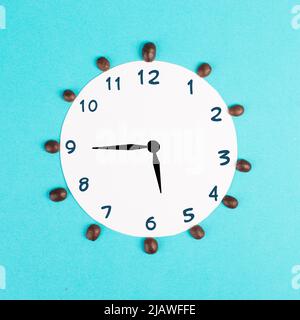 Réveil avec chiffres et grains de café, réveil le matin, ayant une date limite, heure pour une pause, concept minimaliste, fond bleu Banque D'Images