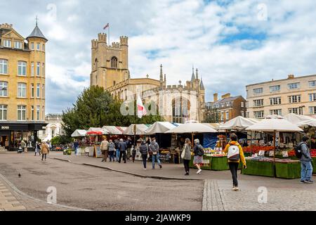 Journée de marché sur la place du marché historique dans le centre de Cambridge, avec vue sur l'église de St Mary le Grand, Cambridge, Cambridgeshire, Angleterre. Banque D'Images