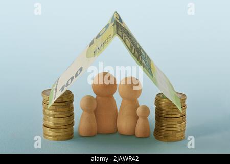 Famille sous maison faite d'argent - concept de la famille, de la maison et de la protection financière Banque D'Images