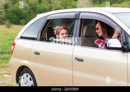 Vacances et voyage. Bonne mère et fille conduit dans une voiture de location. Le concept d'acheter une nouvelle voiture. Banque D'Images