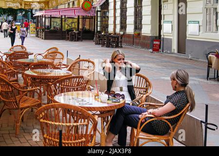 Des filles ukrainiennes parlent dans un café en plein air, Lviv, Ukraine Banque D'Images