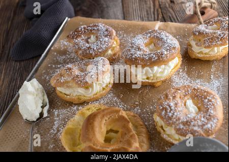 Feuilletés à la crème maison avec garniture de crème fouettée sur une plaque de cuisson Banque D'Images