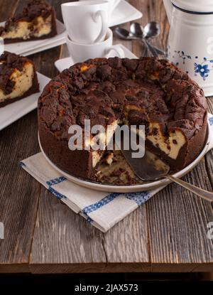 Gâteau au chocolat avec garniture au cheesecake sur table à café en bois Banque D'Images