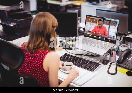Collègues d'affaires multiraciaux, hommes et femmes, discutant du travail avec un ordinateur portable au bureau Banque D'Images