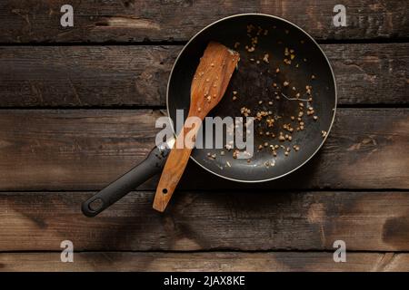 poêle sale après avoir mangé sur une vieille table en bois dans la cuisine à la maison, ustensiles de cuisine sales après le dîner Banque D'Images